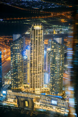 Wall Mural - Abstract blurred bokeh boke background of illuminated cityscape with skyscrapers in Dubai. Moving through modern city street with illuminated. Urban background of Dubai, UAE, United Arab Emirates