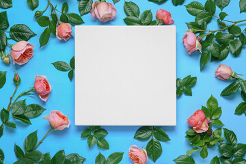 Wall Mural - blank canvas and beautiful pink roses on light blue background, flat lay. space for design