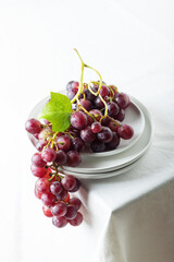 Wall Mural - Red grape on the white linen tablecloth