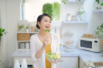 Wall Mural - Healthy Smiling Girl with Bowl of Salad and Fork.