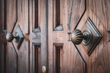 Close-up Of Impressive Wooden Doors With Vintage Round Door Handles.
