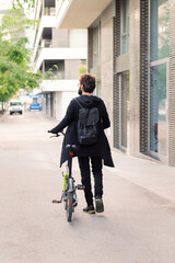 Wall Mural - unrecognizable caucasian man walking with his bike