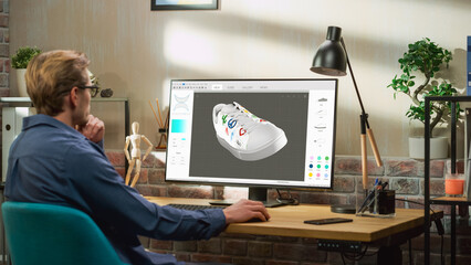 Young Male Footwear Designer Works on 3d Model of Shoe and Change Colours on It While Working on Desktop Computer in Creative Space. Shoe Production Procedure Concept.