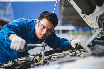 Wall Mural - Asian mechanic in a car repair shop. mechanic in service center car safety check Repair service concept. Professional service concept