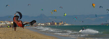 A Group Of Colorful Kitesurf Kites Fly In The Blue Sky By The Wind.