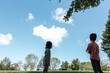 adorable siblings look at a heart shaped cloud