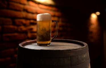 Wall Mural - Beer. Still life with Vintage beer barrel and glass light beer. Fresh amber beer concept. Green hop and gold barley on wooden table. Ingredients for brewery. Brewing traditions