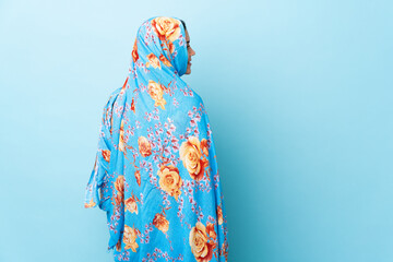 Sticker - Young Moroccan woman with traditional costume isolated on blue background in back position and looking side