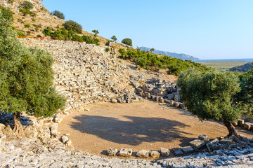 Ruins of Kaunos Ancient Theater in Dalyan or Ortaca in Turkey. Amphitheatre of Kaunos Ancient City. Historical place from ancient civilization. Empty copy space on blue sky. Selective focus.