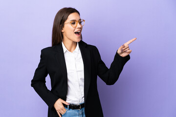 Sticker - Business woman isolated on purple background pointing finger to the side and presenting a product