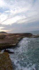 aerial view of rocky cliffs neighboring a beautiful blue sea