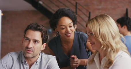 Canvas Print - Excited, diverse and happy colleagues talking about a project in a busy office or agency. Team of joyful employees working on a business proposal together and collaborating for success