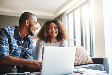 Poster - Happy, excited and cheerful couple browsing on laptop and using the internet for payments and calculating home budget while sitting on sofa. Young husband and wife enjoying convenient online banking