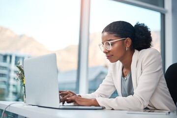 Serious, confident or ambitious business woman thinking, planning and brainstorming idea. Creating entrepreneur typing on laptop, browsing and searching emails online on office technology.
