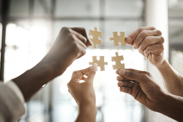 Aufkleber - Diverse team solving a problem together due to teamwork, support and helping each other in the office. Group of business people assembling a puzzle and collaborating in unity