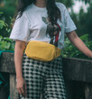 a woman wear yellow crossbody bag