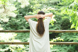 Fototapeta Nowy Jork - 森の中で髪の毛を縛る女性（ひとつ結び）
