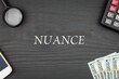 NUANCE - word (text) and money dollars on the table, phone magnifying glass (loupe) and calculator. Business concept, buying goods and products, paying for services (copy space).