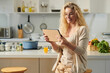 © DragonImages - Portrait of cheerful curly young woman reading recipe on tablet computer before cooking dinner for family