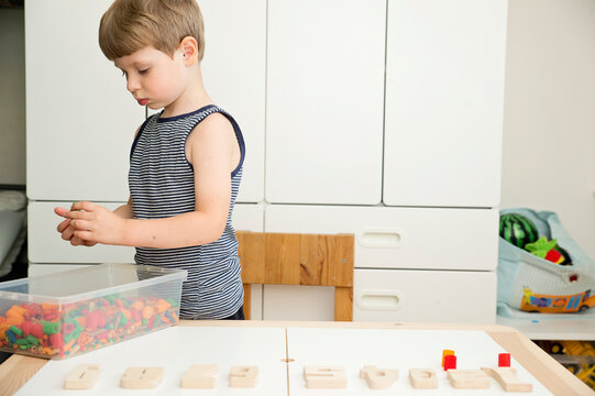 Math with fun. Calculation and marking of uncooked pasta with colored natural wood numbers. Do-it-yourself game. Play at home. The way of learning. Early education, counting game, fine motor skills.