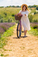 Young Woman Wheeling Her Bicycle Down A Country Lane