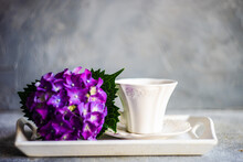 Porcelain Tea Cup On A Tray With A Purple Hydrangea Flower