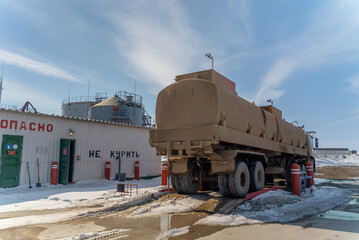 Refueling a truck carrying fuel at a gold mining site.