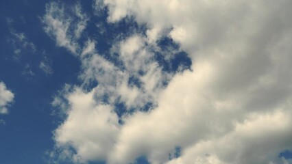 beautiful white fluffy clouds slowly float against the blue sky on a warm sunny summer day. timelaps