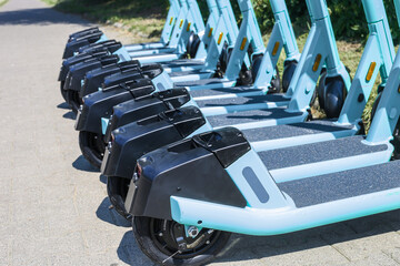 Electric scooters for public share standing outside in european city center public mobile transport, close up