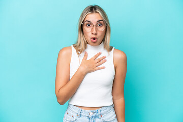 Canvas Print - Young caucasian woman isolated on blue background surprised and shocked while looking right