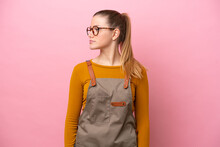 Woman With Apron Isolated On Pink Background Looking To The Side