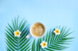 © Maryna - Milk coffee with plumeria flowers and palm leaves on blue. Cozy vocational morning. Coffee break. Relaxing atmosphere. Eco life. Summer style. Hotel room service. Exotic countries.