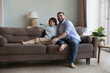 © fizkes - Little boy sit on cozy sofa with young loving bearded father, daddy spend weekend with preschooler 6s son smile look at camera. Leisure together, happy fatherhood, understanding, family bond concept