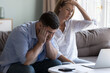 © fizkes - Stressed spouses manage family finances, analyze expenses, check savings and budget, looks disappointed due to mortgage arrears, unpaid utility bills, debt notice. Lack of money, high utility concept