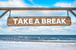 Take a break wooden sign against beach