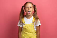 Caucasian Girl Child In Yellow Clothes Waist-length Portrait On A Pink Background