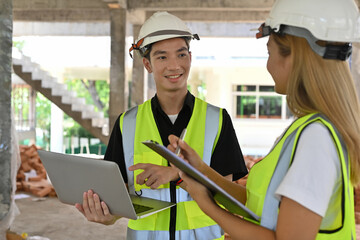 portrait of two construction engineers or architects wearing white safety helmet and reflective clot