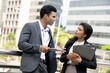 © Atstock Productions - Indian businessman meeting with businesswoman outdoors in the city with office buildings in background
