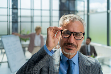 Poster - Businessman with colleagues in the background in office.