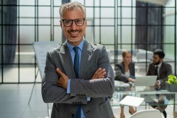 Poster - Businessman with colleagues in the background in office.