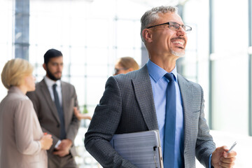 Poster - Businessman with colleagues in the background in office.