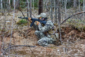 a human in the forest shoots from a machine gun