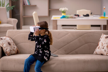 Young little girl enjoying virtual glasses at home