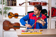 © Elnur - Young man repairing musical instruments at workshop