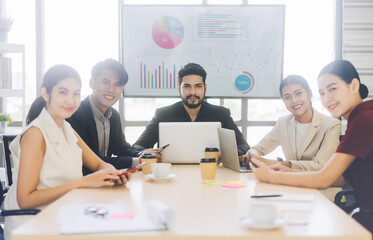 Wall Mural - Group of business professional asian man and woman sitting in meeting room table eye looking at camera