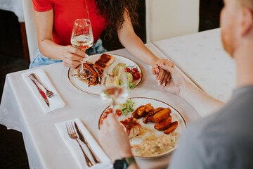 Wall Mural - Young couple having lunch with white wine in the restaurant