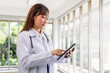 © Danai - Female doctor using finger touching digital tablet working at hospital,Tele-medical health care service concept