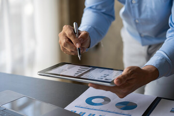 Crop shot of image young man hand using tablet check monthly expenses finance and investment, accounting, calculating taxes, the corporate financial report of a company