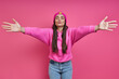 Leinwandbild Motiv Beautiful woman in hooded shirt keeping arms outstretched and puckering against pink background
