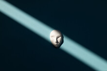 White Mask With Neutral Facial Expression With Shadows On Blue Background
